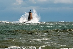 Great Waves Cover Stone Lighthouse Tower in Maine